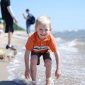 summer fun at the beach, boy playing in the waves
